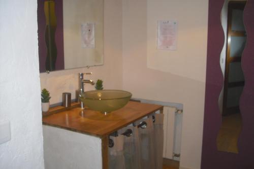 a bathroom with a bowl sink on a wooden counter at Le Luberon Lou Mas Li Pitchoun in Gordes