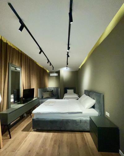 a bedroom with a large white bed and a couch at GRAND JNK Boutique Hotel in Kukës