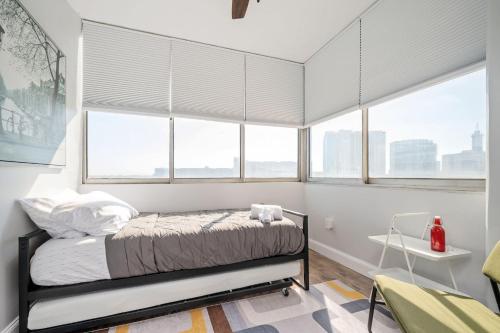a bedroom with white walls and windows with a bed at Atlanta Downtown City View Free Onsite Parking Entire Condo LM1607 in Atlanta