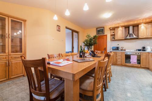 a kitchen with a large wooden table and chairs at Просторна вила с впечатляващ изглед в централен Балкан in Kravenik