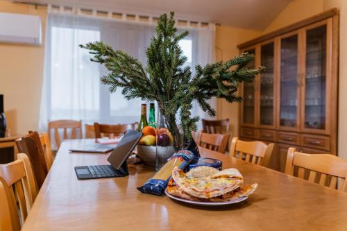 une table à manger avec un ordinateur portable et un arbre de Noël dans l'établissement Просторна вила с впечатляващ изглед в централен Балкан, à Kravenik