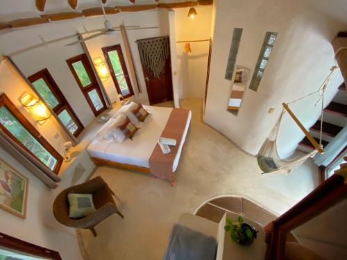 uma vista sobre uma sala de estar com uma cama e um sofá em Casa Cacahuate Holbox-Casa entera con jardin-Whole house with garden em Ilha Holbox