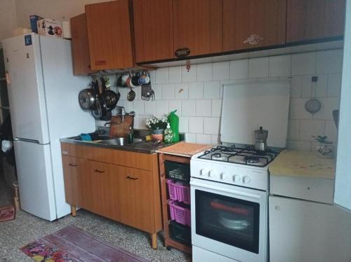 een keuken met een fornuis en een witte koelkast bij Palm Tree Room 1 in Prato
