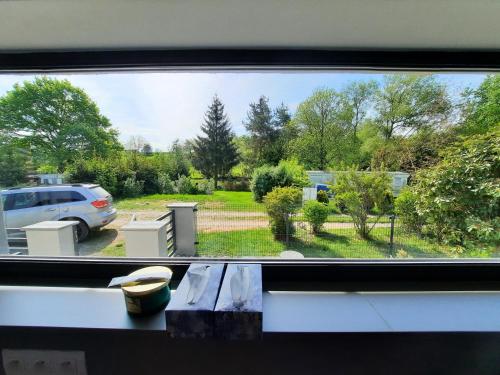 a window with a view of a parking lot at bungalov na břehu Labe s vlastním molem in Pardubice