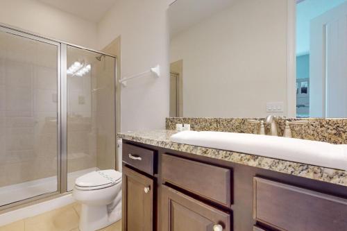 ein Bad mit einem WC, einem Waschbecken und einer Dusche in der Unterkunft Magic Mirage in Orlando