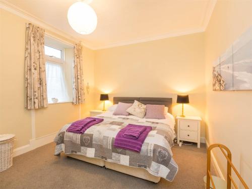 a bedroom with a bed with purple sheets and a window at 4 Bed in Brodick CA381 in Brodick