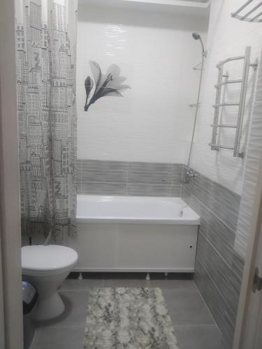 een badkamer met een bad, een toilet en een wastafel bij Уют in Bisjkek