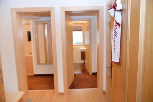 a room with a door and a hallway with a bathroom at Haus Edring in Tux