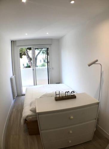 - une chambre avec un lit et une commode avec une lampe dans l'établissement Nice bas Cimiez- Coquet F1, climatisée, Parking, à Nice