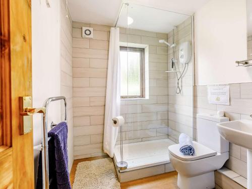 a bathroom with a shower and a toilet and a sink at 3 Bed in Todmorden 82953 in Todmorden