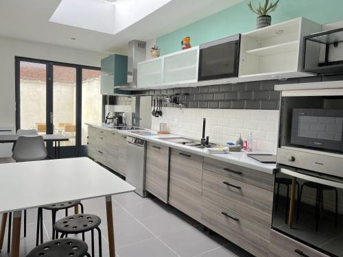 una cucina con bancone bianco e tavolo di Maison 5 chambres proche toutes commodités a Roubaix