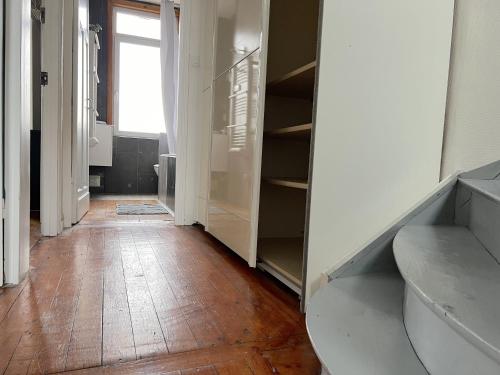 un couloir avec un placard avec un plancher en bois dans l'établissement Maison 5 chambres proche toutes commodités, à Roubaix