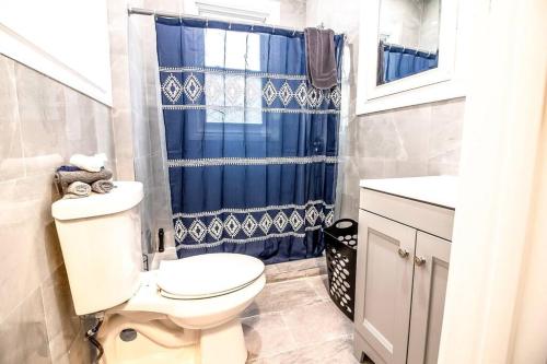 baño con aseo y cortina de ducha azul en Cozy 1 bedroom Apartment Sleeps 2-3, en Niagara Falls
