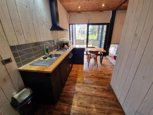 uma cozinha com lavatório e piso em madeira em Surf Lodge Punta de Lobos em Pichilemu