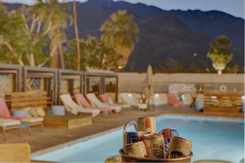 a resort with a pool and chairs and a table with a bowl of drinks at The Infusion Beach Club in Palm Springs