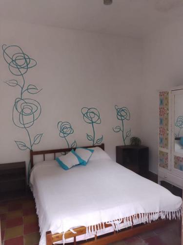 a bedroom with a white bed with black flowers on the wall at Lo de Gavy in Concepción del Uruguay