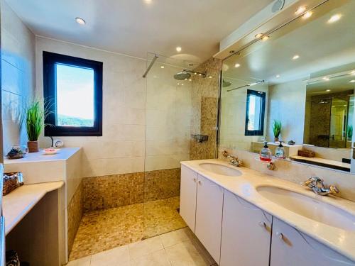 La salle de bains est pourvue de 2 lavabos et d'une douche. dans l'établissement Somptueux deux pieces, entre mer & piscine !, à Mandelieu-la-Napoule