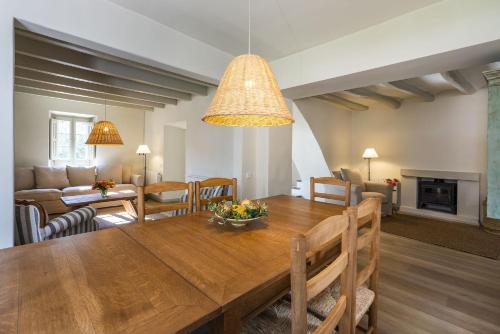 comedor y sala de estar con mesa de madera en Finca Can Romeu alojamiento rural entre viñedos en Font-Rubí