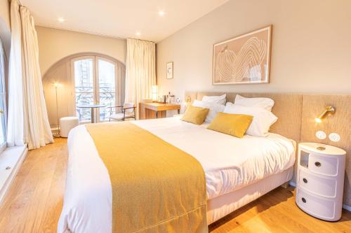 ein Schlafzimmer mit einem großen Bett und einer gelben Decke in der Unterkunft La Maison De Blanche in Bordeaux
