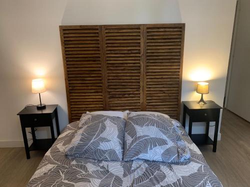 a bedroom with a bed with two lamps on two tables at MAISON AVEC JACUZZI in Bourgoin