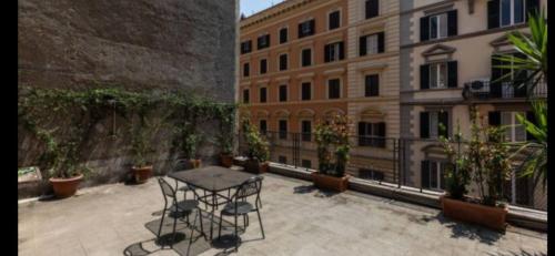 patio ze stołem na dziedzińcu z budynkami w obiekcie Prati Zen Boutique Studio w Rzymie