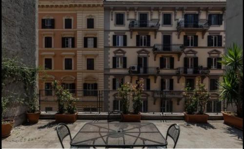 dziedziniec ze stołem i krzesłami przed budynkiem w obiekcie Prati Zen Boutique Studio w Rzymie