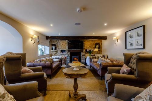 LlandeglaにあるThe Grousemoor - North Wales luxury 7 bedroom holiday rentalのソファと暖炉付きの広いリビングルーム
