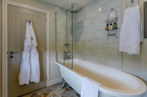 a bathroom with a bath tub and a shower at The Grousemoor - North Wales luxury 7 bedroom holiday rental in Llandegla