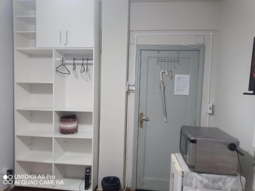 a door to a kitchen with a closet and a microwave at Aconchego do Lar Centro BH Apto 633 Rua da Bahia 187 in Belo Horizonte