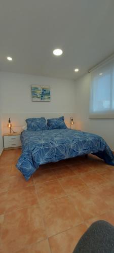 1 cama con edredón azul en una habitación en LAS OLAS ATICO PENHOUSE with TERRACE and SEA VIEW en La Caleta