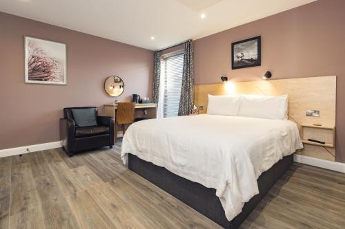um quarto de hotel com uma cama e uma cadeira em Port 56 em Portstewart