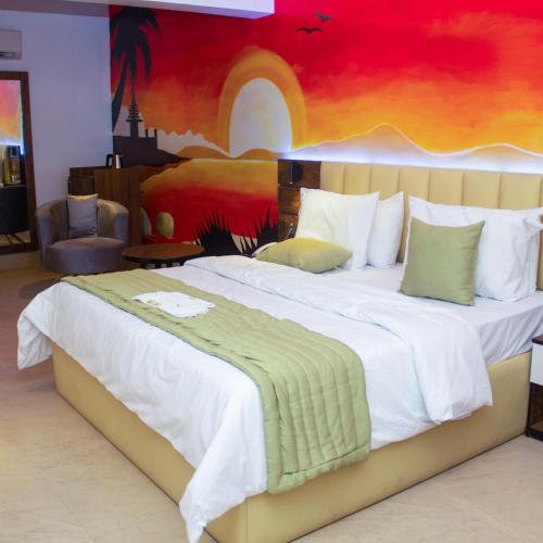 ein Schlafzimmer mit einem großen Bett und einem Gemälde an der Wand in der Unterkunft Merzino Palace in Uyo