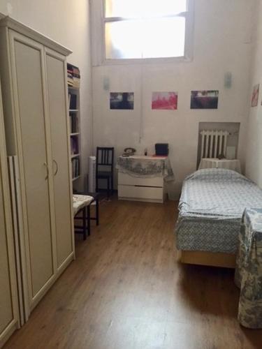 a room with a bedroom with a bed and a window at Single room in Santo spirito olttrarno in Florence