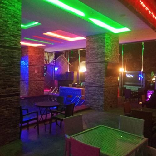 a bar with ping pong tables and neon lights at Merzino Palace in Uyo