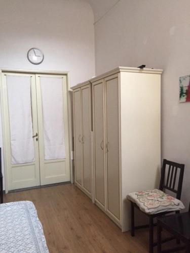 a bedroom with a bed and a cabinet and a chair at Single room in Santo spirito olttrarno in Florence
