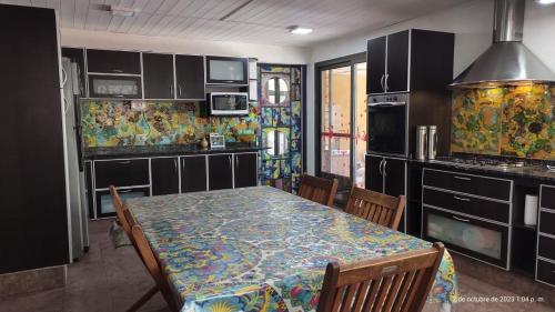 une cuisine avec une table et des chaises et une cuisine avec une table dans l'établissement Hermosa casa en barrio la toma, à Capilla del Monte