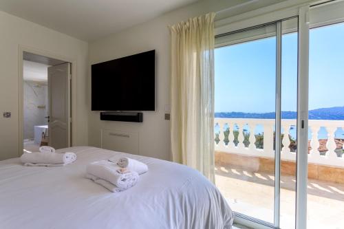 a bedroom with a bed with a view of the ocean at VILLA BELLE VUE VI4394 By Riviera Holiday Homes in Villefranche-sur-Mer