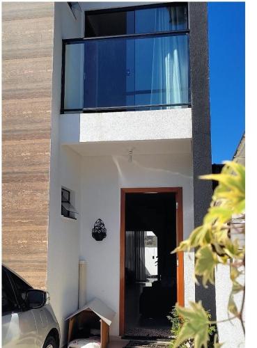 a house with a door and a car parked in front of it at Geminado Ibicaré com quarto privativo em casa compartilhada in Joinville