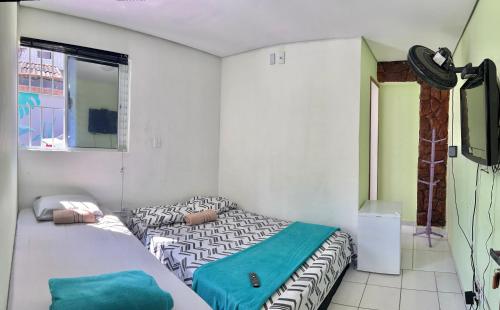 een kleine slaapkamer met een bed en een raam bij Pousada Villa Brasil Ocian in Praia Grande