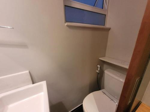baño con aseo blanco y ventana en Suhcasa Leme Studio Confort en Río de Janeiro