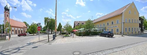 a street with a yellow building and a stop sign at Hotel zum Alten Wirt in Langenbach