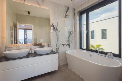 uma casa de banho com 2 lavatórios e um espelho grande em Platinum em Opatija