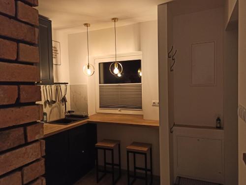 a kitchen with a counter and a window and stools at Mini house - apartament, domek do wynajęcia in Solec-Zdrój