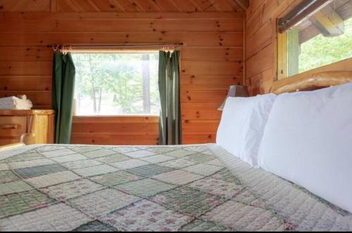 a bedroom with a bed and a window in a cabin at Adelaide's Den in Townsend