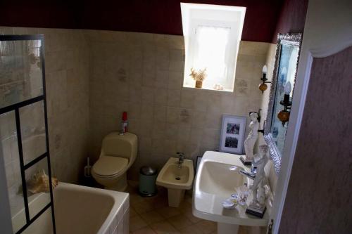 ein Badezimmer mit einem Waschbecken, einem WC und einem Waschbecken in der Unterkunft La Mégritnière chambre d'hôtes in Mégrit