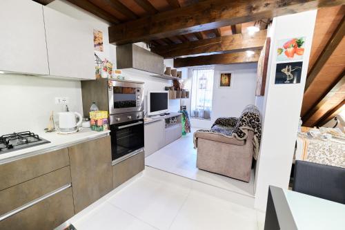 a kitchen with white walls and wooden ceilings at Residenza e Campanoun in Santarcangelo di Romagna