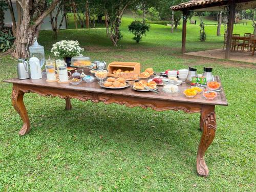 un tavolo di legno con del cibo sopra nell'erba di Pousada Boutique Villa Chafariz Tiradentes a Tiradentes