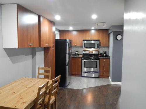 a kitchen with stainless steel appliances and wooden cabinets at Nox Hostel in Toronto