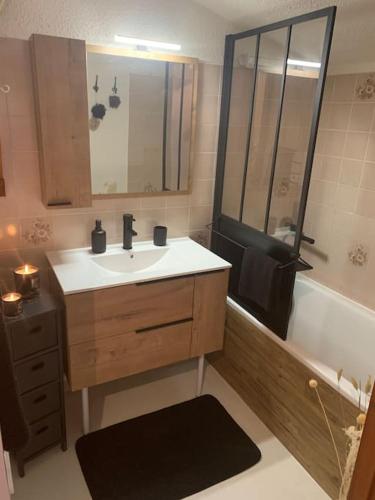 une salle de bain avec un lavabo et une baignoire dans l'établissement Chalet le Daim appartement 6 pers Vue Mont-Blanc, à Combloux