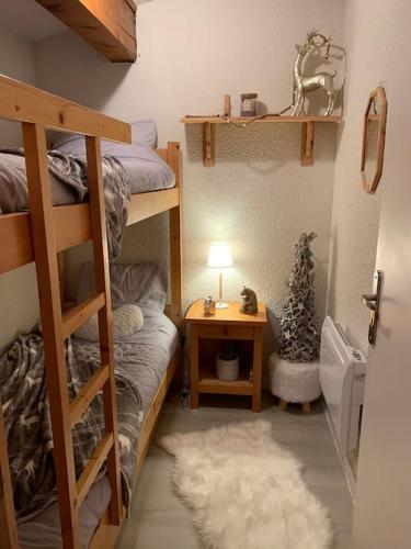 - une chambre avec des lits superposés et une table avec une lampe dans l'établissement Chalet le Daim appartement 6 pers Vue Mont-Blanc, à Combloux